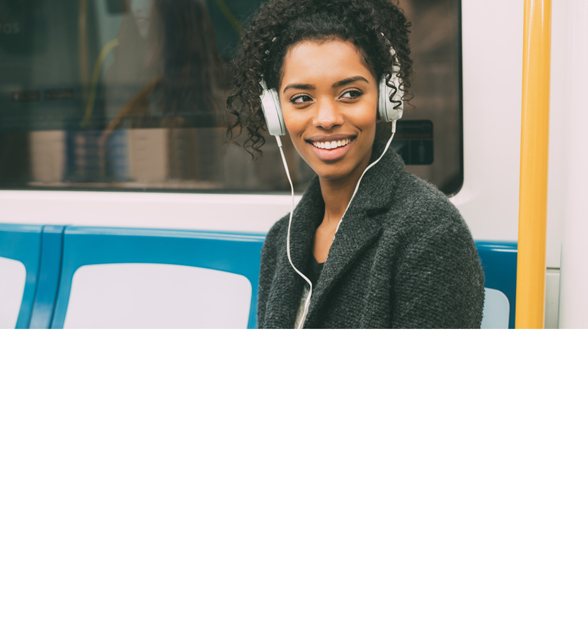 a woman on the traind with large headphones looking to the side of the camera