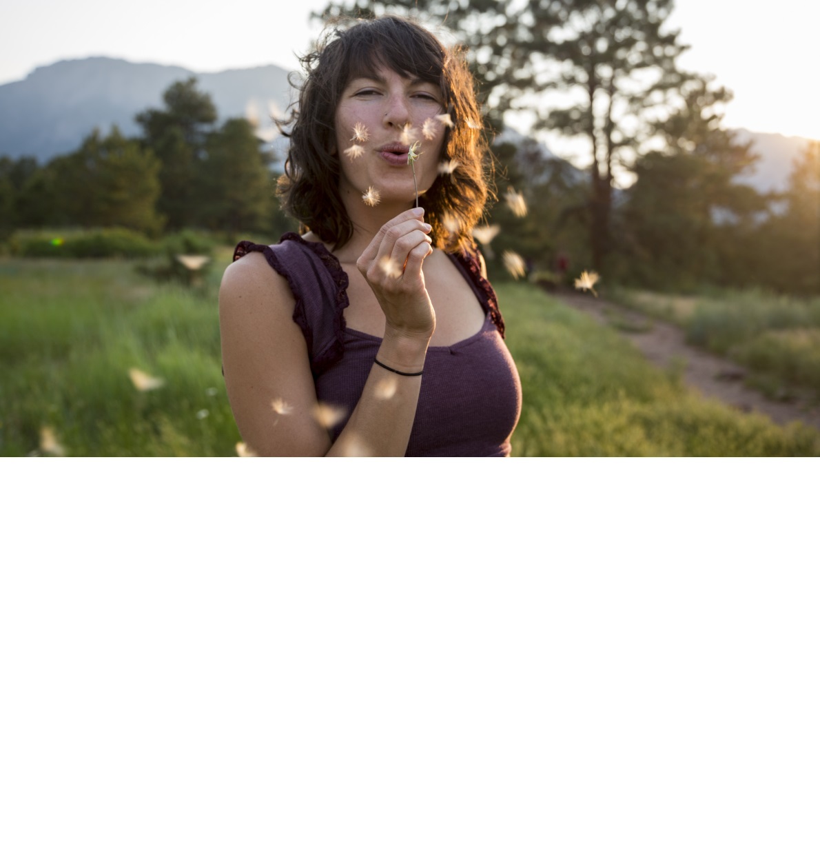 Woman blowing a dandelion